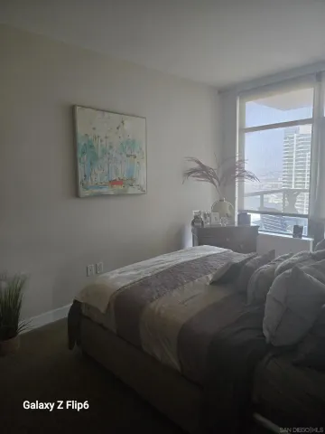 a bedroom with a bed and a painting on the wall