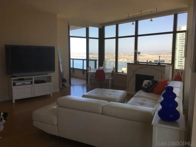 a living room with furniture a flat screen tv and a floor to ceiling window