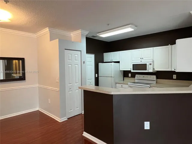 a kitchen with stainless steel appliances a refrigerator sink and microwave