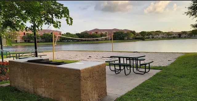 a view of a lake with couches in wooden deck and lake view