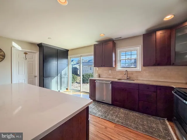 a kitchen with stainless steel appliances granite countertop a sink refrigerator and window