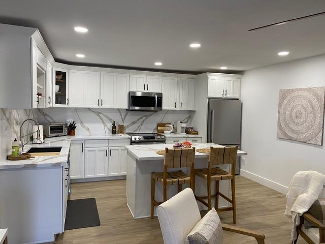 a kitchen with a sink a stove a refrigerator cabinets and a dining table