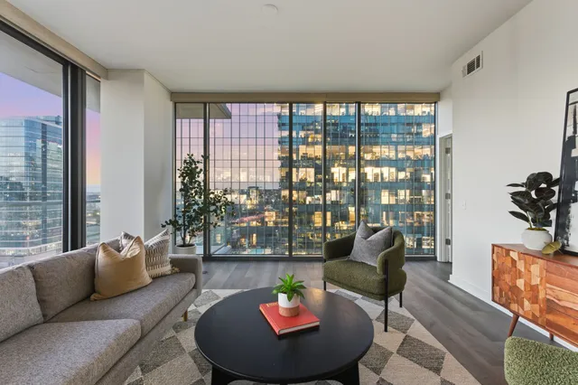 an empty room with wooden floor closet and windows