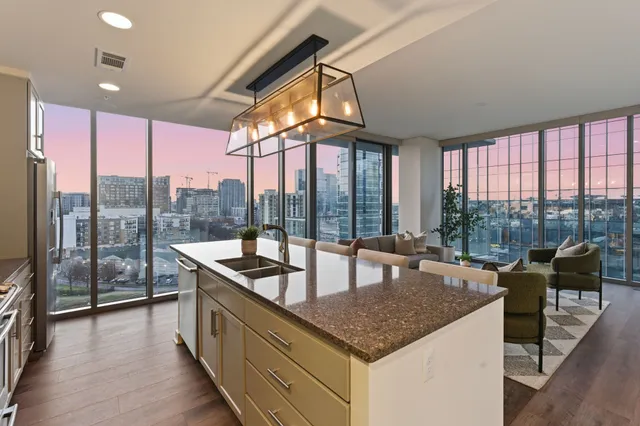 a view of a kitchen with a sink and large window