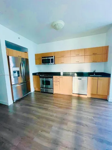 a view of empty room with wooden floor and cabinets