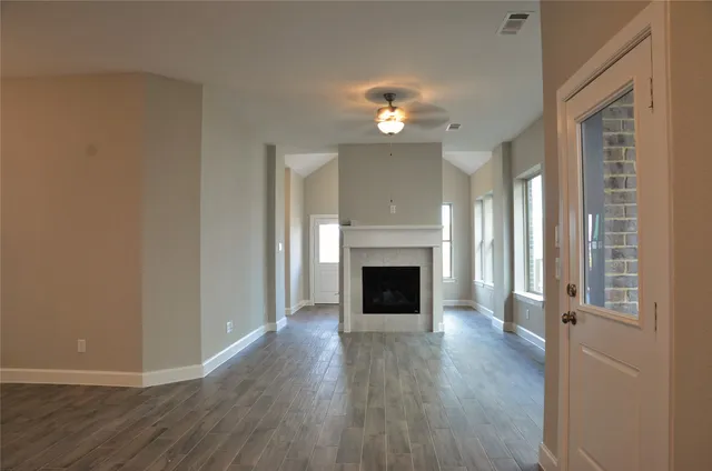 a view of a livingroom with wooden floor and a fireplace