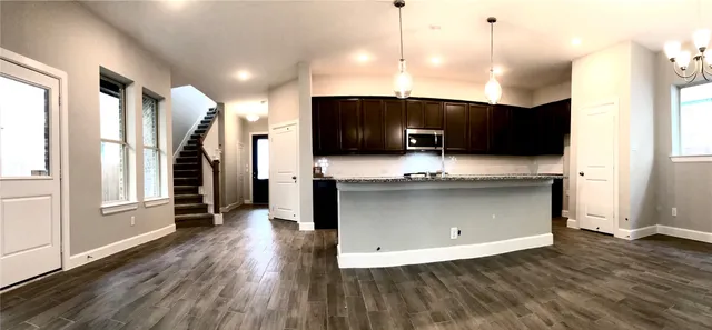 a view of kitchen with stainless steel appliances granite countertop a stove a sink and a microwave