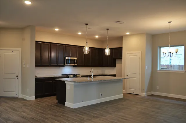 a kitchen with kitchen island stainless steel appliances a sink and a counter top space
