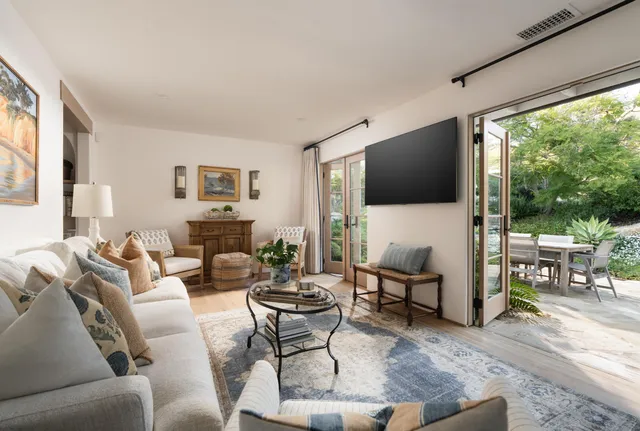 a living room with furniture a flat screen tv and a large window