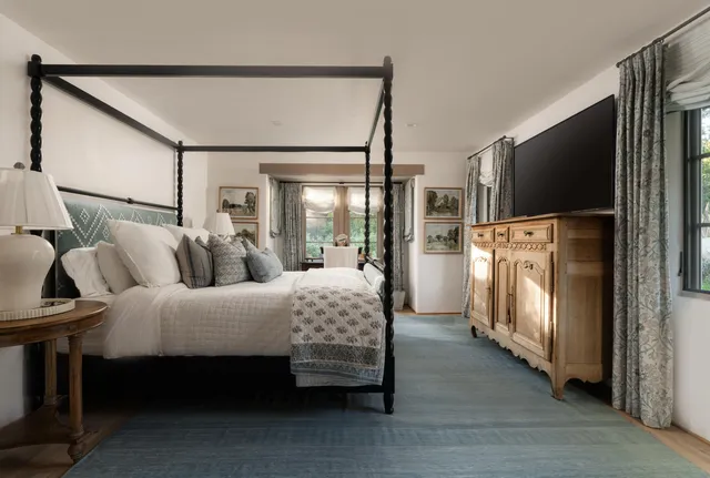 a room with furniture a flat screen tv and a refrigerator