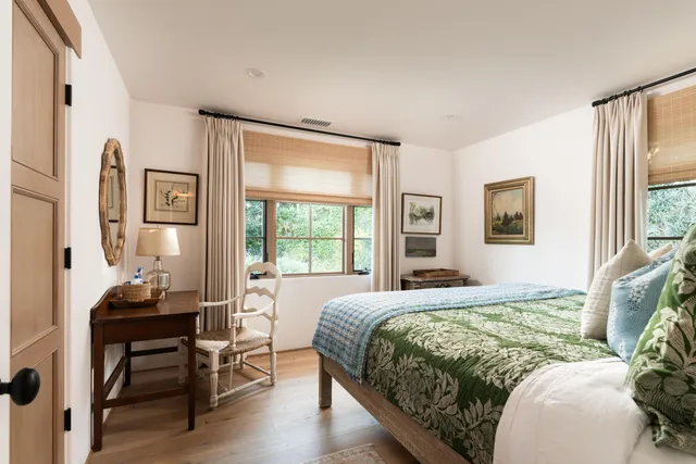 a bedroom with a bed and a table in it with wooden floor
