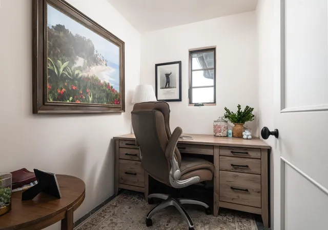 a view of a workspace with furniture and a window