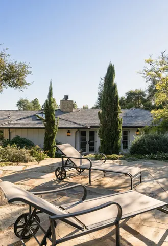 a view of a patio with a table and chairs under an umbrella