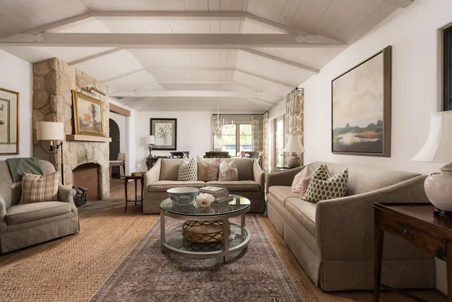 a living room with furniture fireplace and a large window
