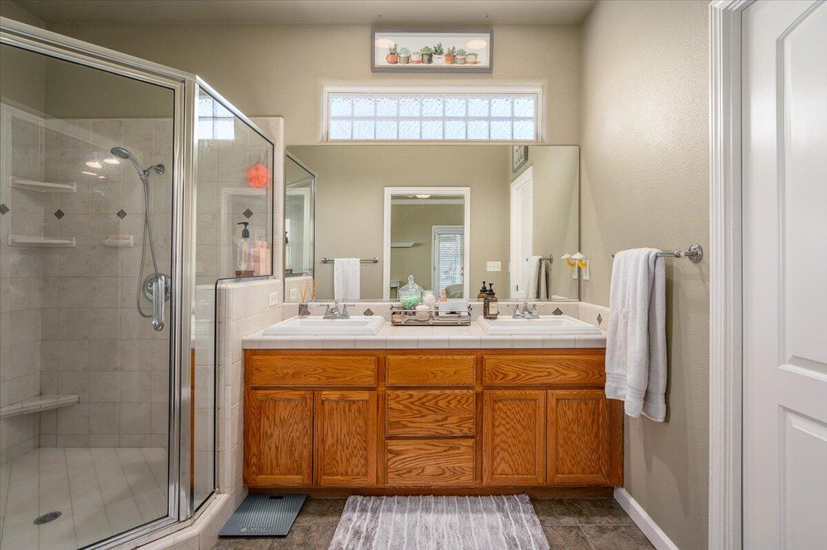 2122 Edinburgh Way Redding, CA 96003 - Photo 19 of 61 a bathroom with a sink a mirror and a shower