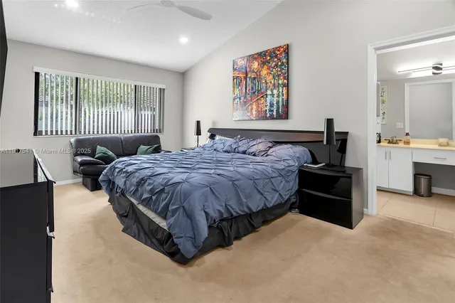 a spacious bedroom with a bed a dresser next to a window