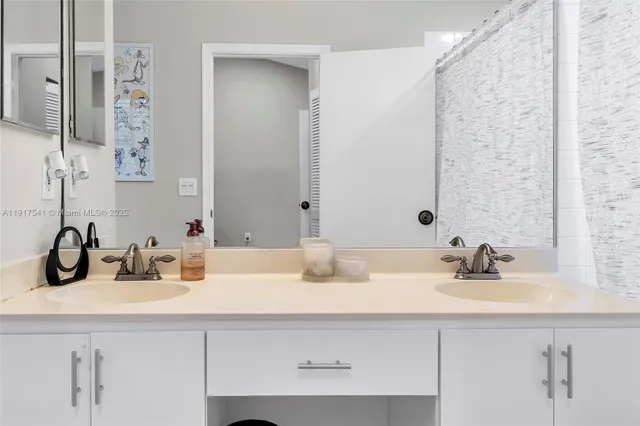 a bathroom with double sink and a mirror