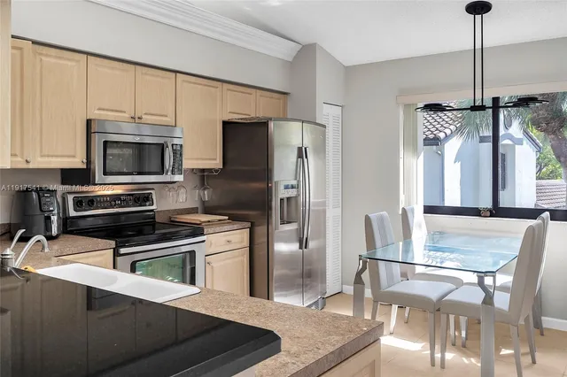 a kitchen with stainless steel appliances a stove a refrigerator and a dining table