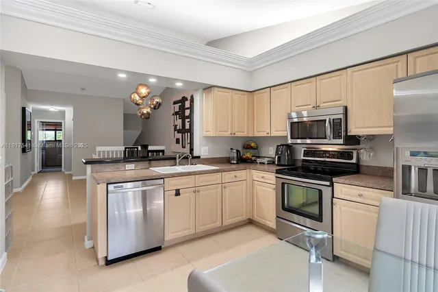 a kitchen with stainless steel appliances granite countertop a stove a sink and a microwave
