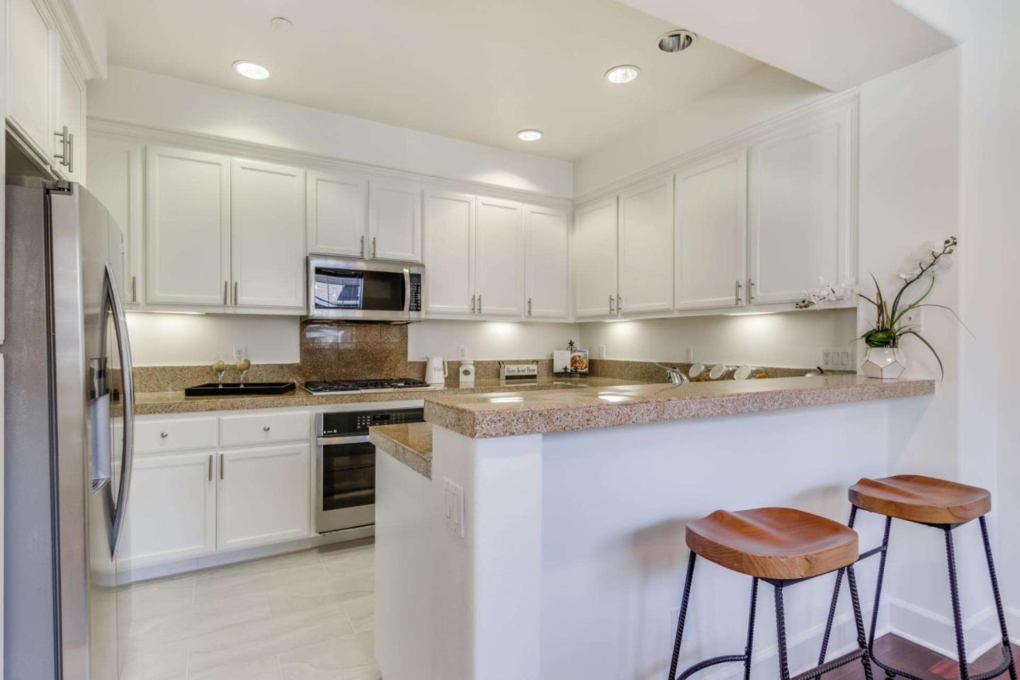100 Live Oak Way, Unit 104 Belmont, CA 94002 - Photo 14 of 37 a kitchen with granite countertop a stove cabinets and a refrigerator