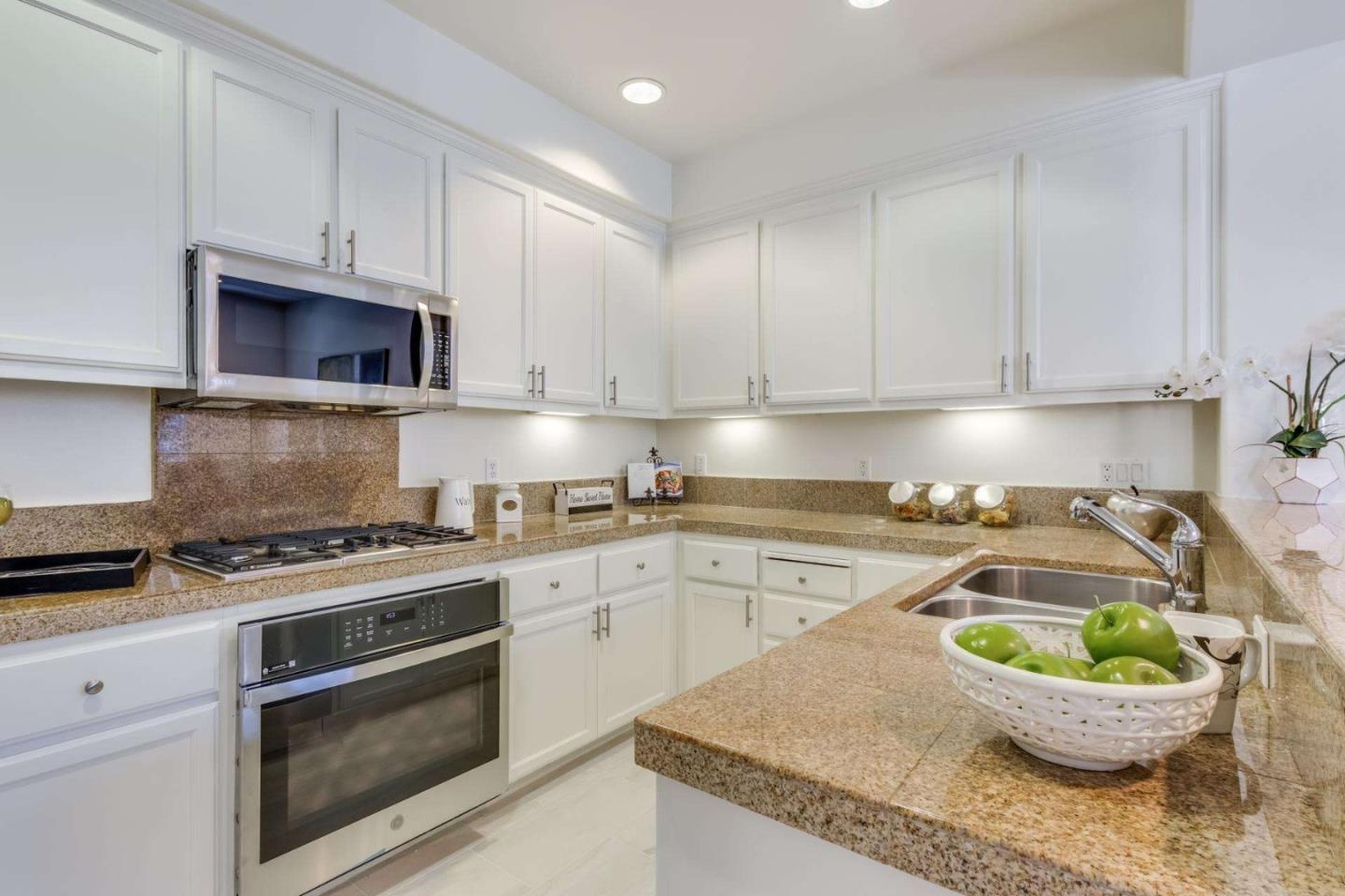 100 Live Oak Way, Unit 104 Belmont, CA 94002 - Photo 15 of 37 a kitchen with granite countertop a stove a sink and a granite counter tops