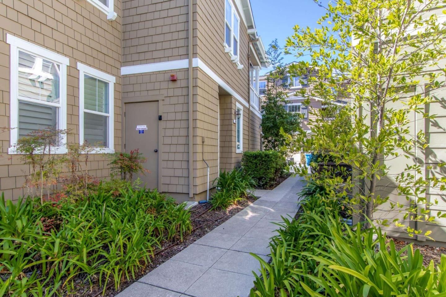 100 Live Oak Way, Unit 104 Belmont, CA 94002 - Photo 2 of 37 a view of a pathway with flower plants and wooden fence