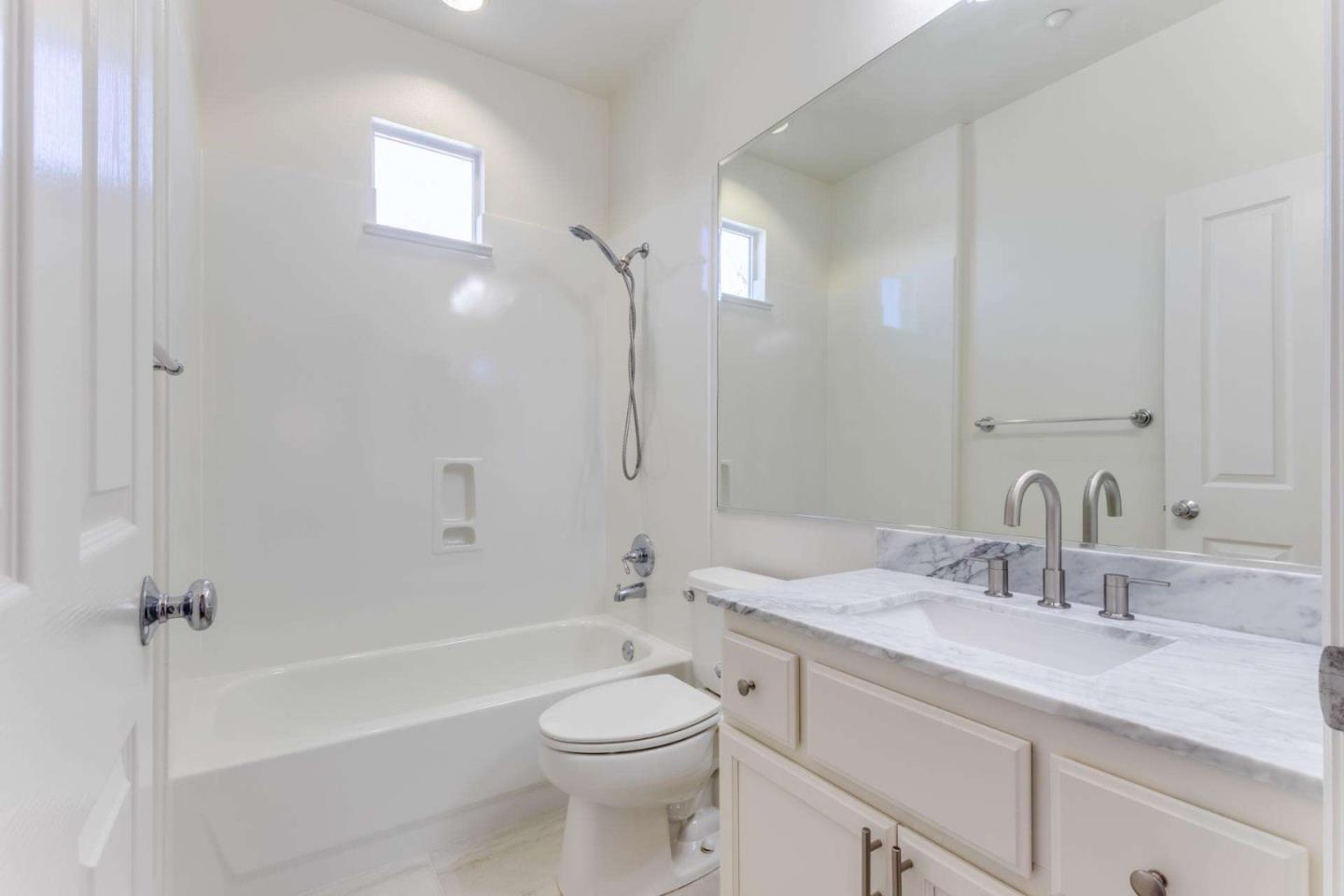 100 Live Oak Way, Unit 104 Belmont, CA 94002 - Photo 23 of 37 a bathroom with a granite countertop sink a toilet and shower