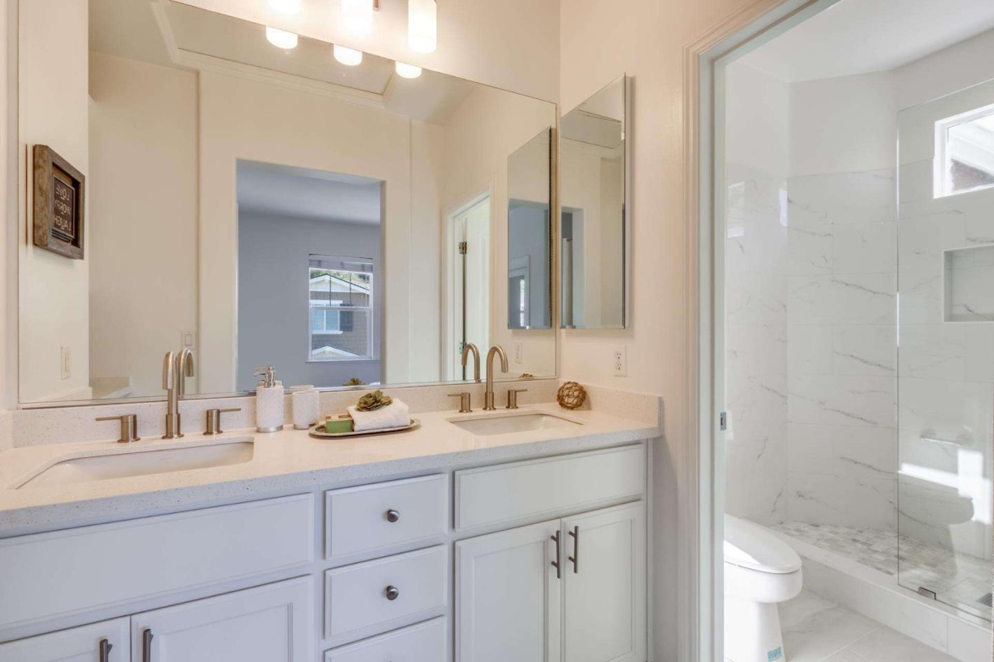 100 Live Oak Way, Unit 104 Belmont, CA 94002 - Photo 28 of 37 a bathroom with double vanity sink a mirror and a shower