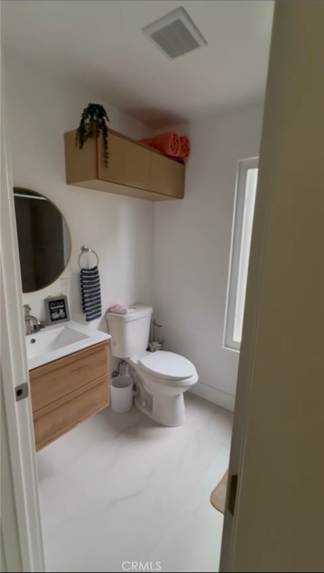 18727 Bassett Street Reseda, CA 91335 - Photo 7 of 8 a bathroom with a toilet sink and mirror