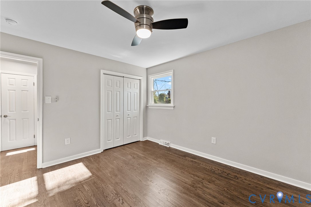 8005 Three Chopt Road Henrico, VA 23229 - Photo 23 of 28 an empty room with wooden floor ceiling fan and windows