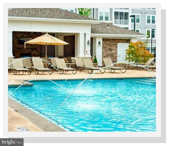 7873 Wormans Mill Road Frederick, MD 21701 - Photo 28 of 30 a view of a swimming pool with a table and chairs under an umbrella