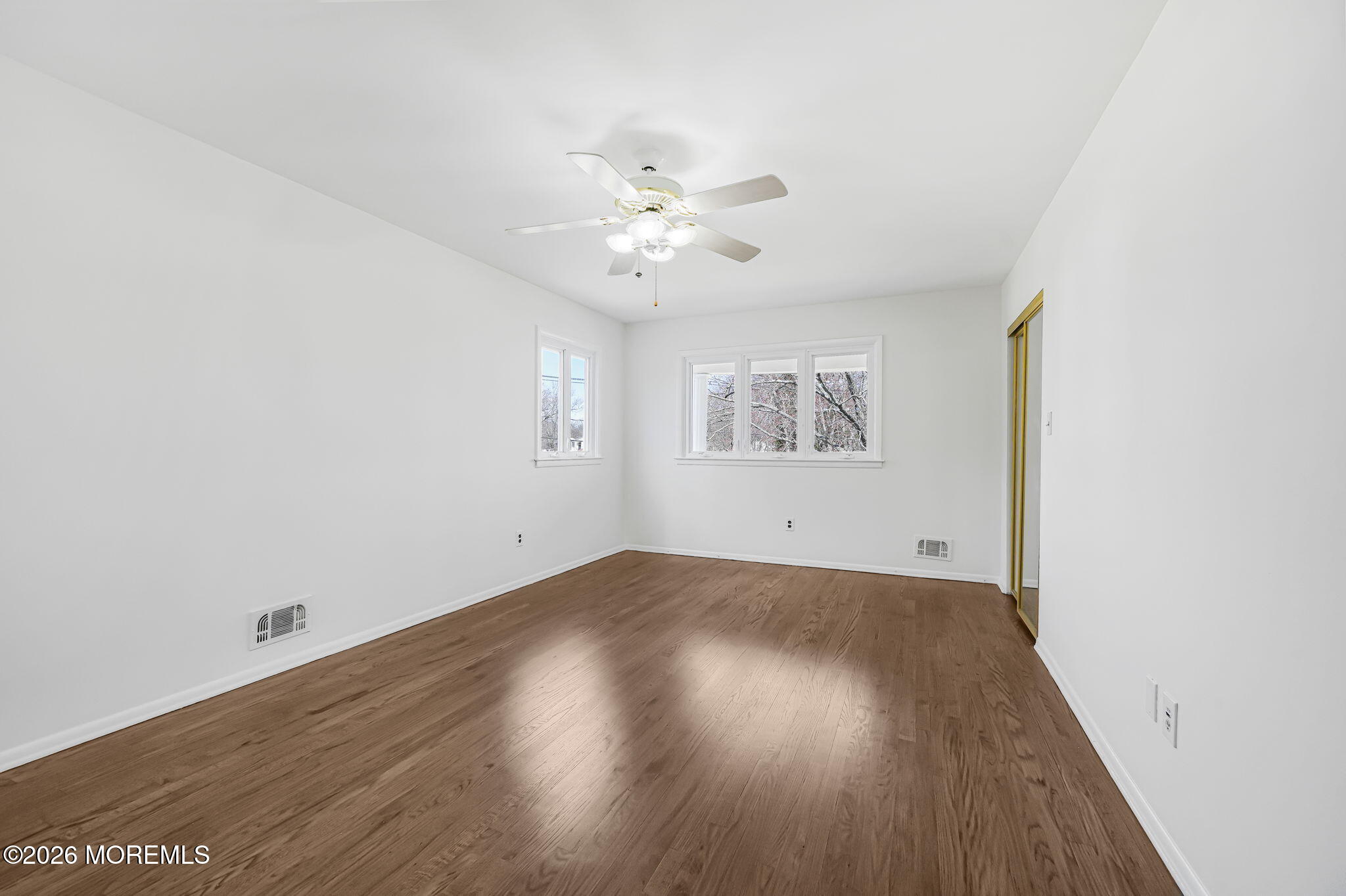 1 Sudbury Road Morganville, NJ 07751 - Photo 23 of 43 an empty room with wooden floor and windows