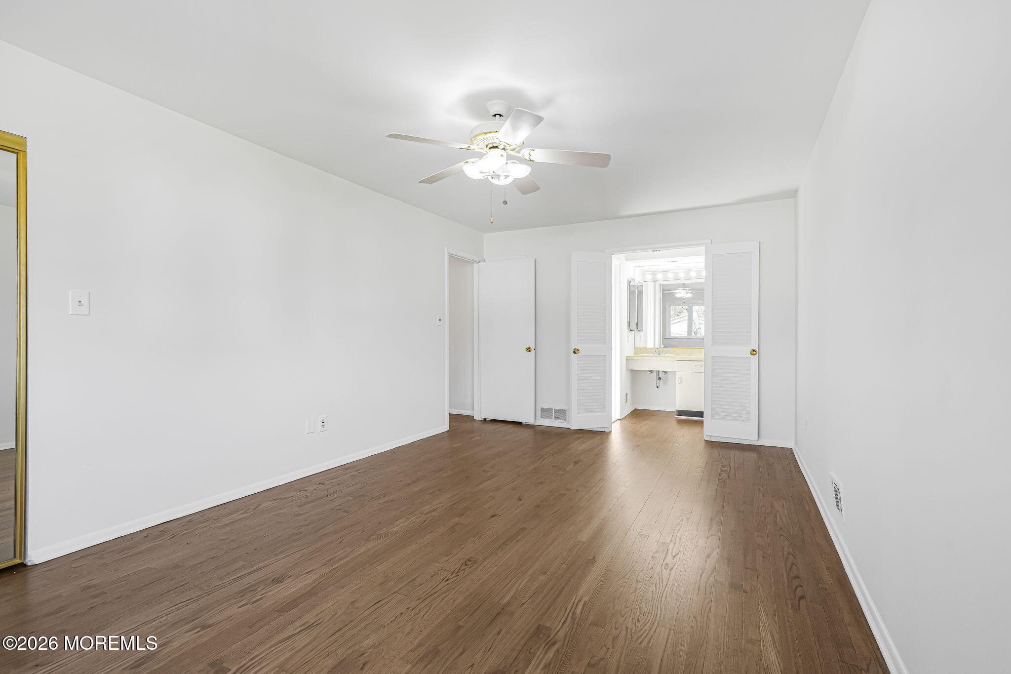 1 Sudbury Road Morganville, NJ 07751 - Photo 25 of 43 a view of an empty room with wooden floor and a ceiling fan