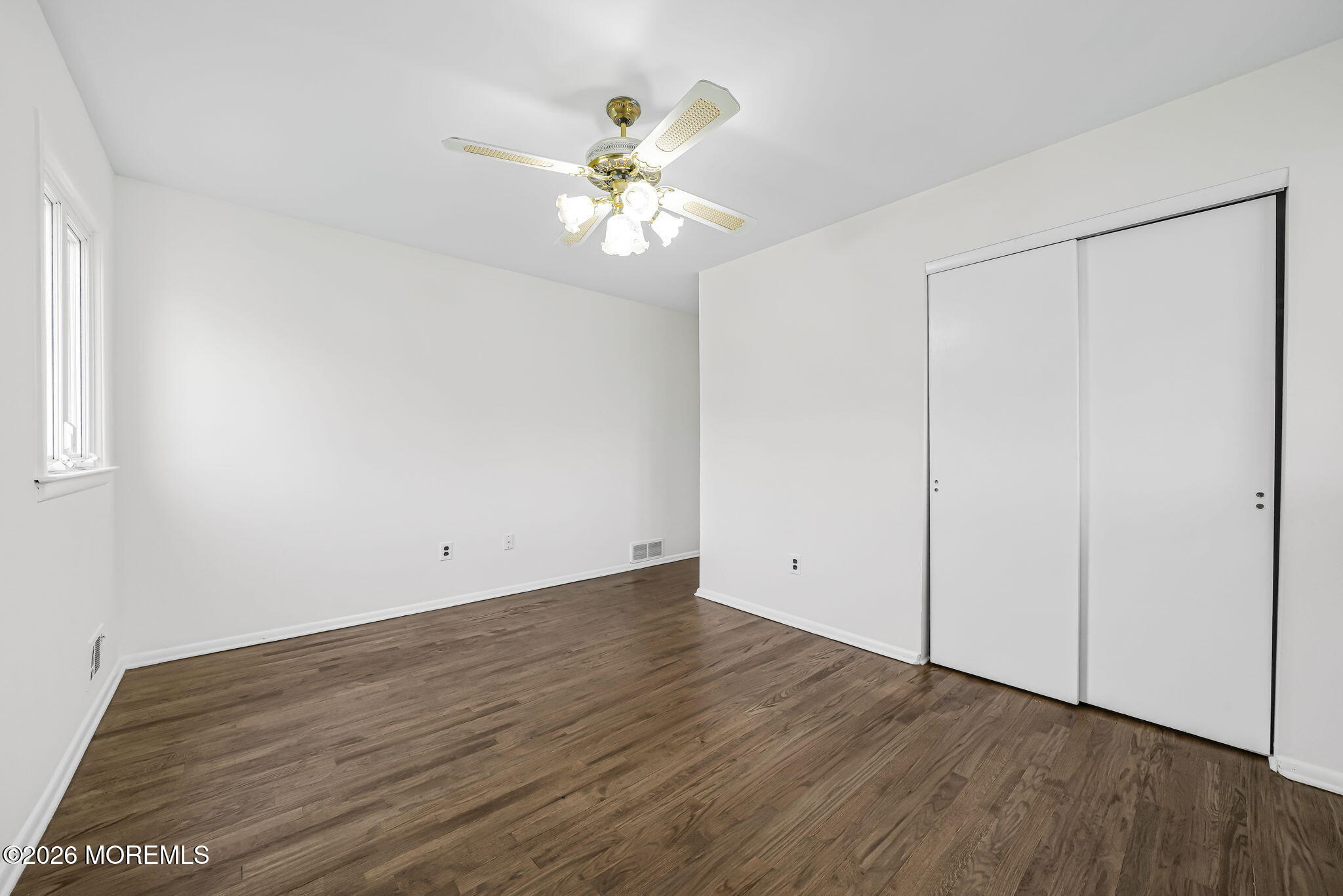 1 Sudbury Road Morganville, NJ 07751 - Photo 30 of 43 an empty room with wooden floor closet and fan