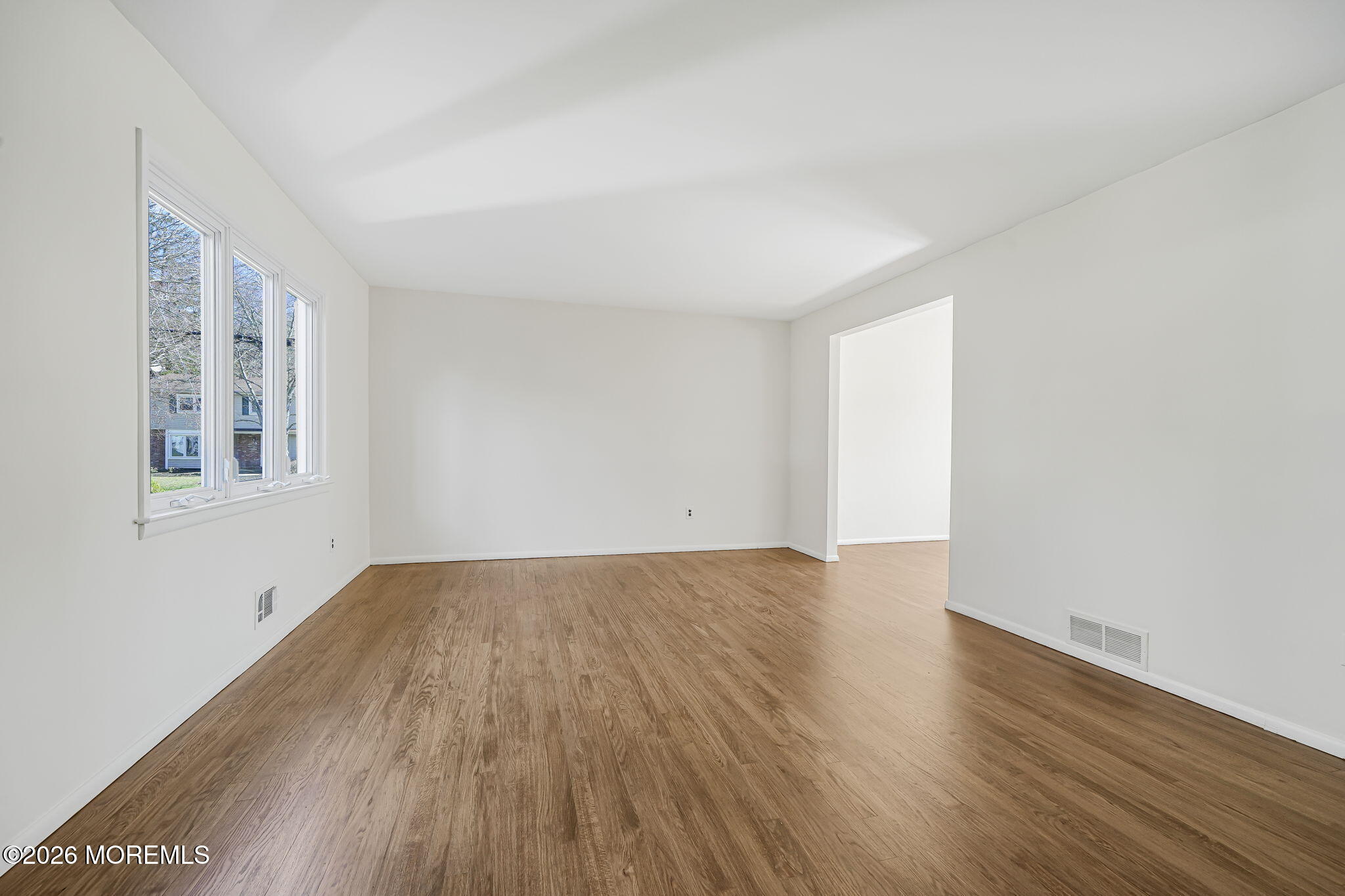 1 Sudbury Road Morganville, NJ 07751 - Photo 9 of 43 an empty room with wooden floor and windows
