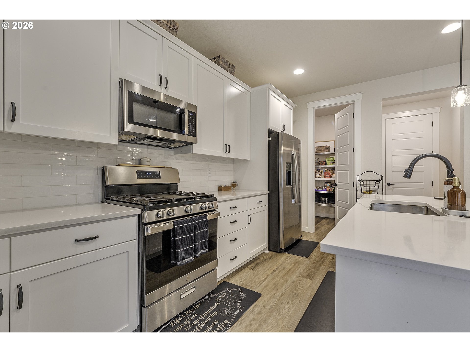 1156 Tansy Lane Canby, OR 97013 - Photo 14 of 35 a kitchen with stainless steel appliances a stove microwave sink refrigerator and cabinets