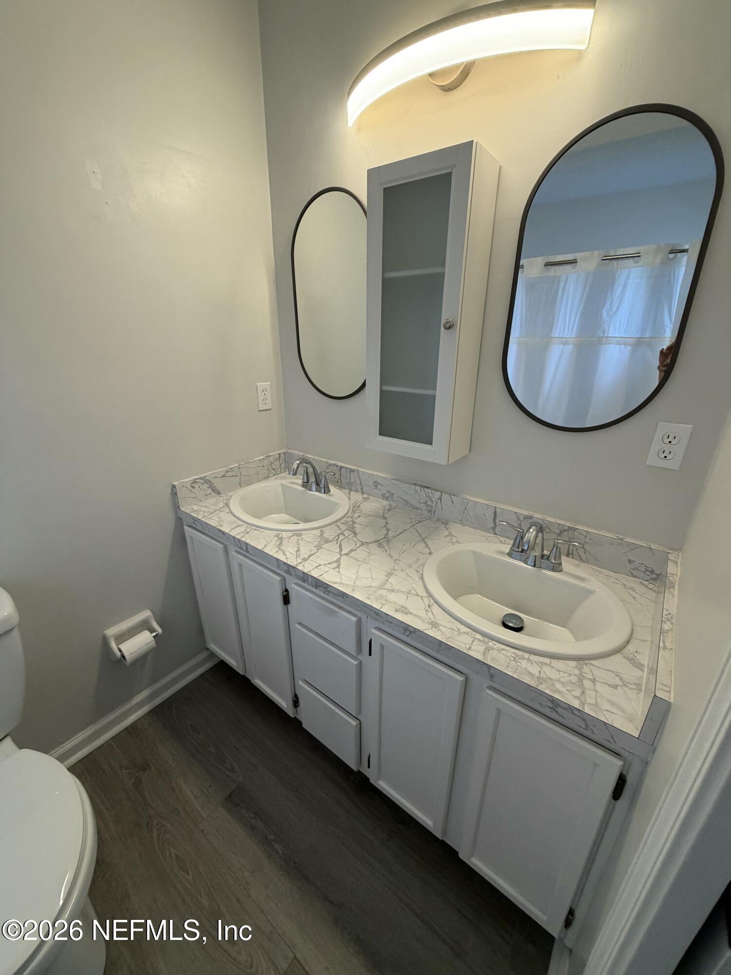 286 Main Street Atlantic Beach, FL 32233 - Photo 18 of 46 a bathroom with a toilet sink and mirror