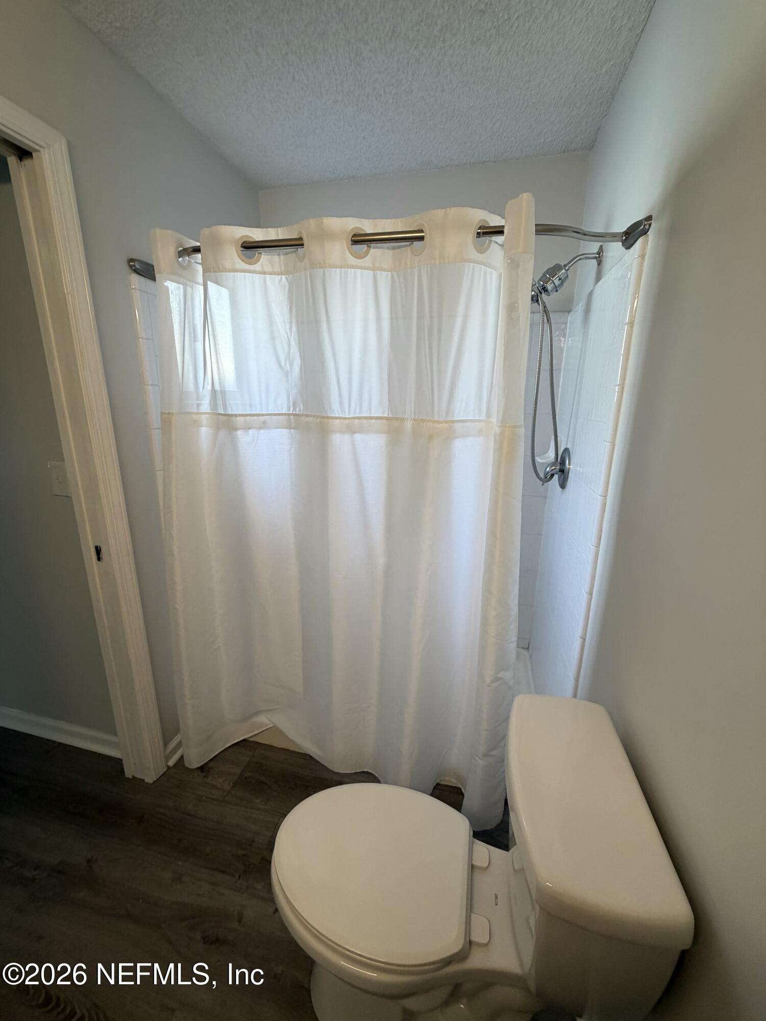 286 Main Street Atlantic Beach, FL 32233 - Photo 19 of 46 a bathroom with a toilet and a shower curtain