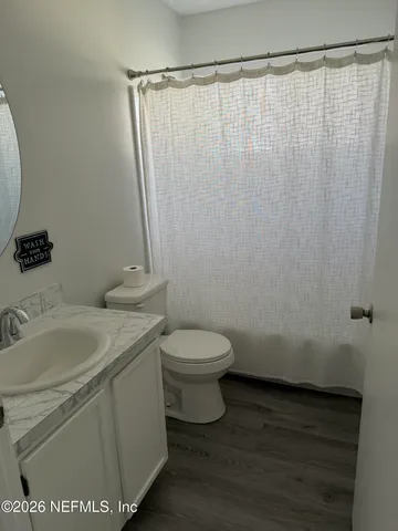 a bathroom with a granite countertop toilet and a sink