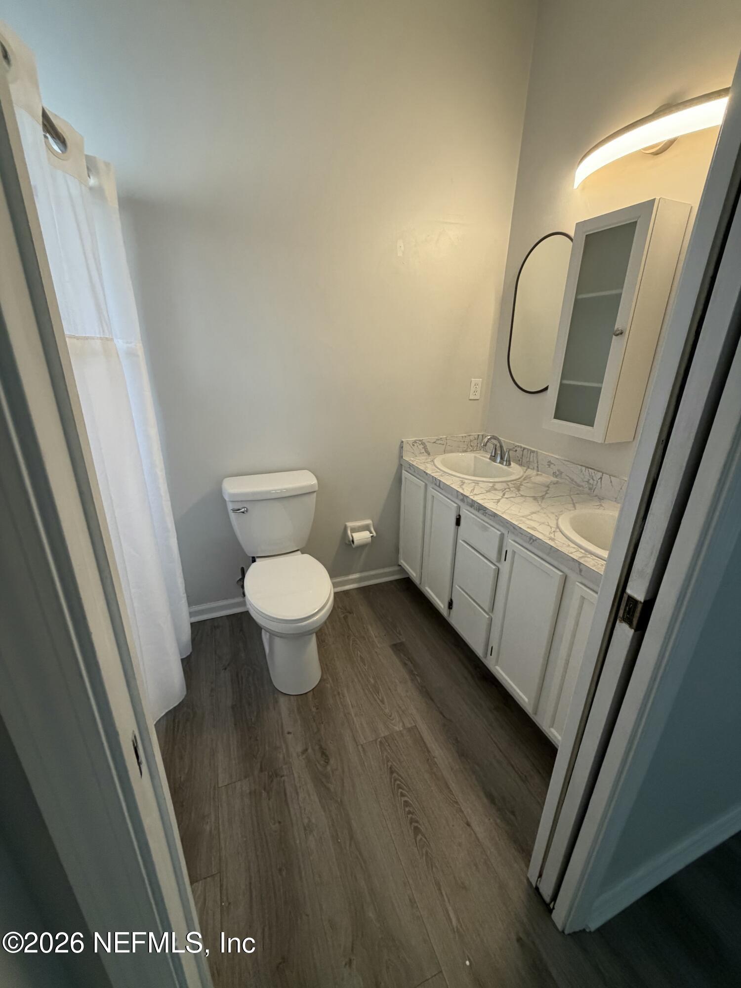 286 Main Street Atlantic Beach, FL 32233 - Photo 24 of 46 a bathroom with a granite countertop toilet a sink and a mirror