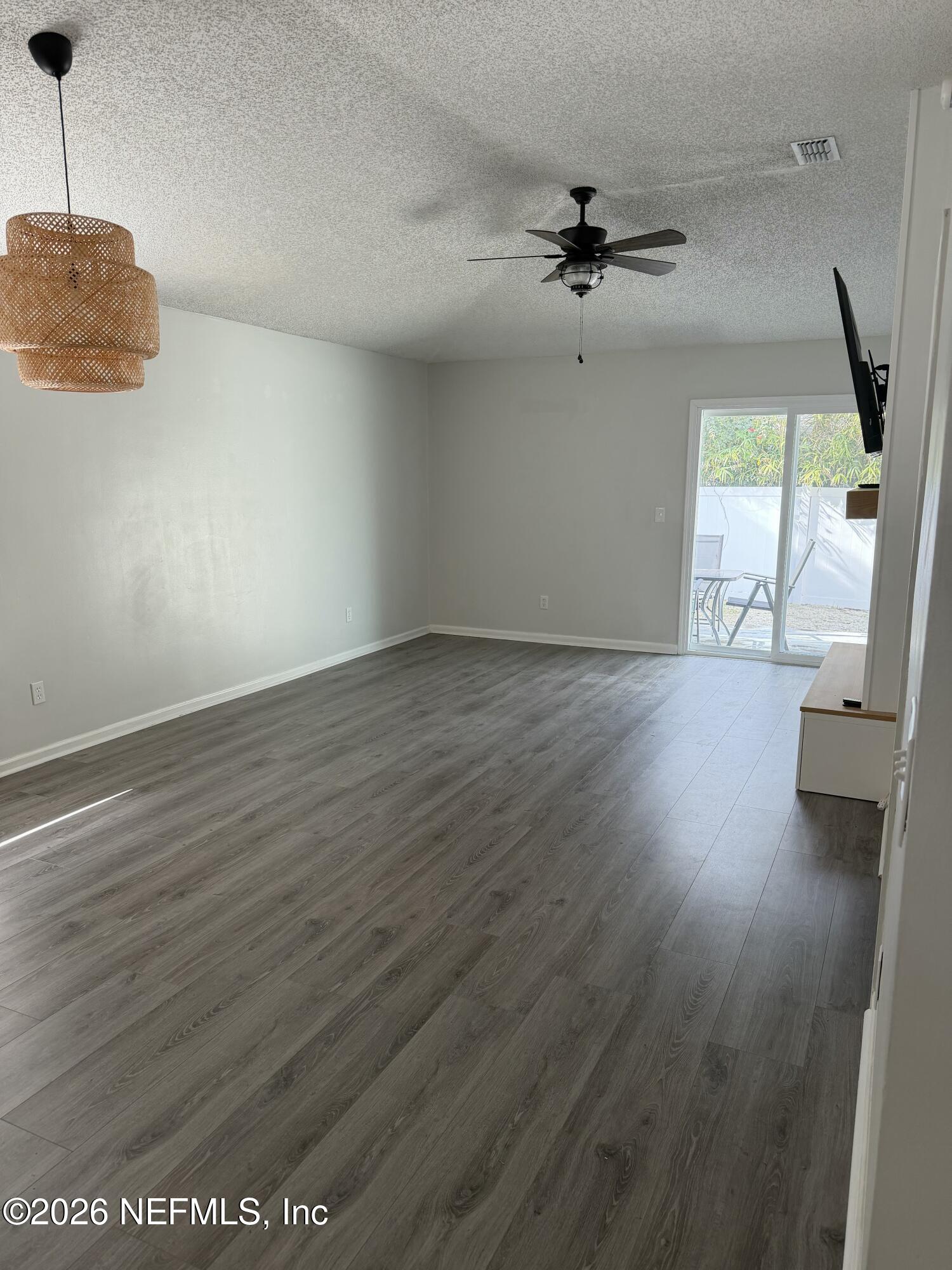286 Main Street Atlantic Beach, FL 32233 - Photo 10 of 46 an empty room with wooden floor fan and windows