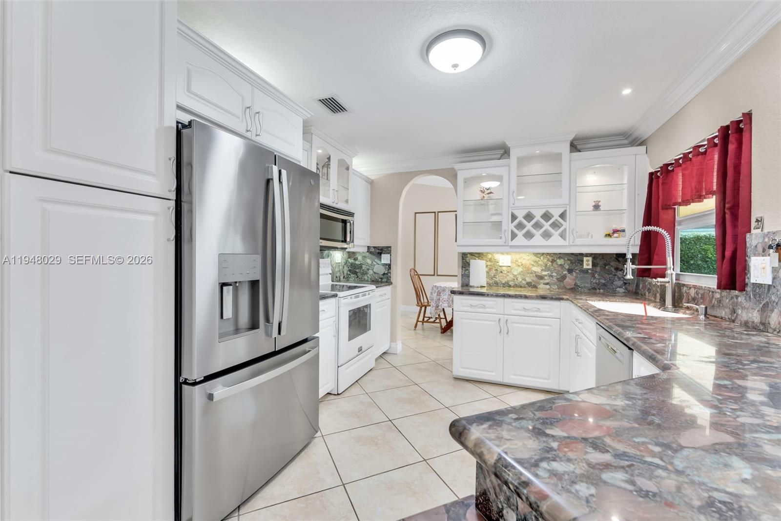 11628 Southwest 50th Street Cooper City, FL 33330 - Photo 12 of 22 a kitchen with stainless steel appliances granite countertop a refrigerator sink and stove