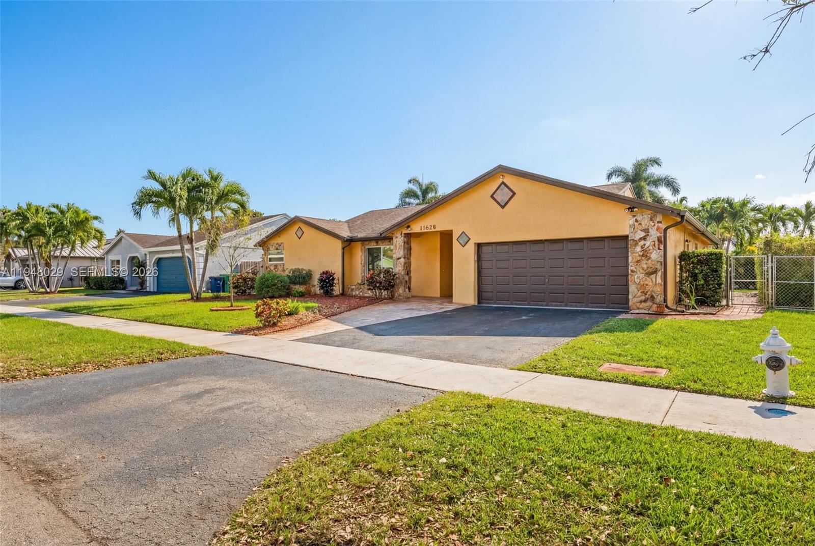 11628 Southwest 50th Street Cooper City, FL 33330 - Photo 4 of 22 a front view of a house with a yard and garage