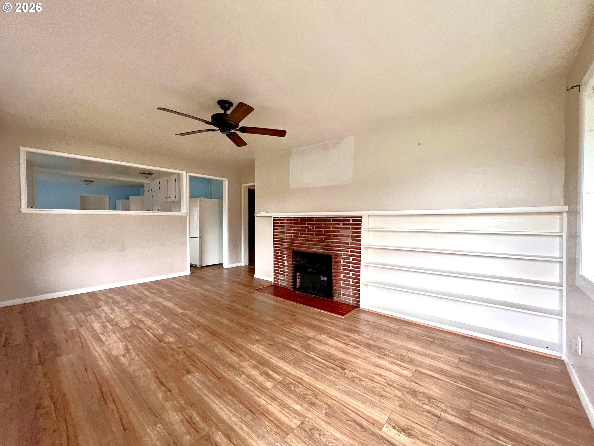 94191 10th Street Gold Beach, OR 97444 - Photo 20 of 33 a view of a livingroom with a fireplace a ceiling fan and wooden floor