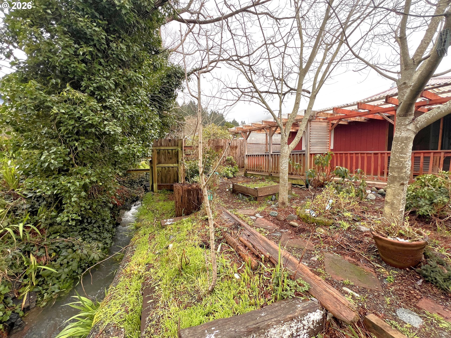 94191 10th Street Gold Beach, OR 97444 - Photo 4 of 33 a view of a yard with plants and large trees