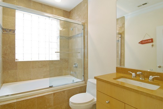 1037 West Monroe Street, Unit 2 Chicago, IL 60607 - Photo 10 of 12 a bathroom with a granite countertop sink toilet and shower