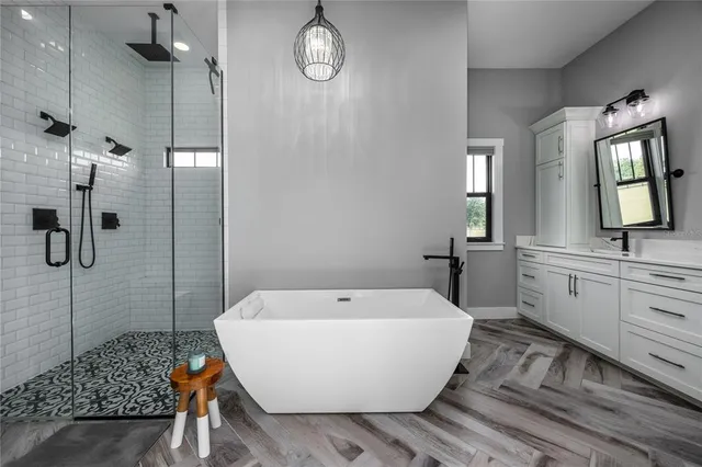 a view of a white house with large trees and a yard