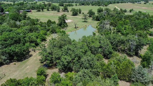 an aerial view of a house with a yard and lake view
