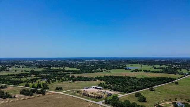 an aerial view of residential houses with outdoor space and trees