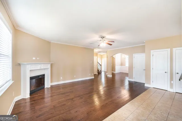 a view of an empty room with wooden floor and fireplace